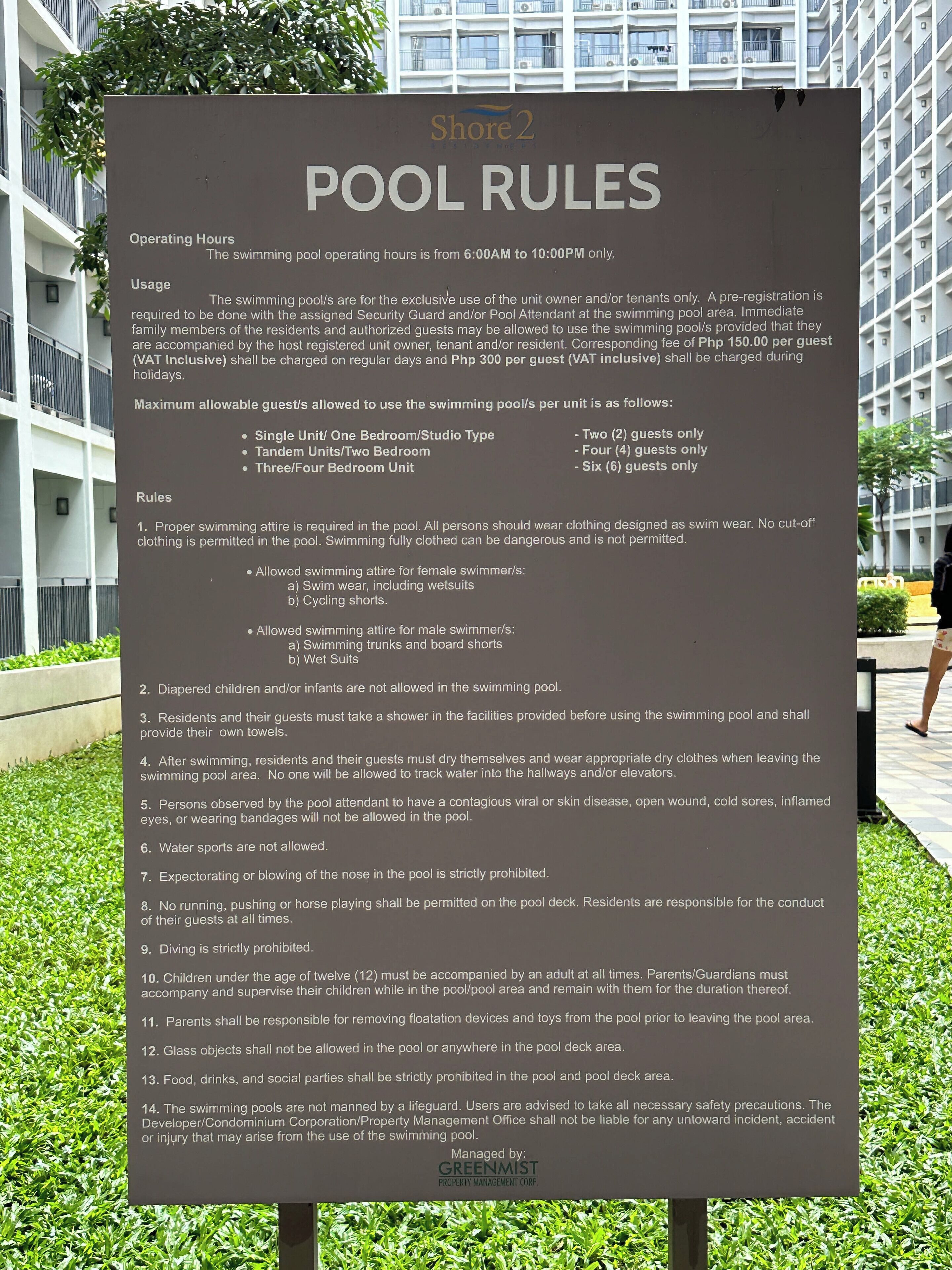 A sign listing pool rules for a residential building.