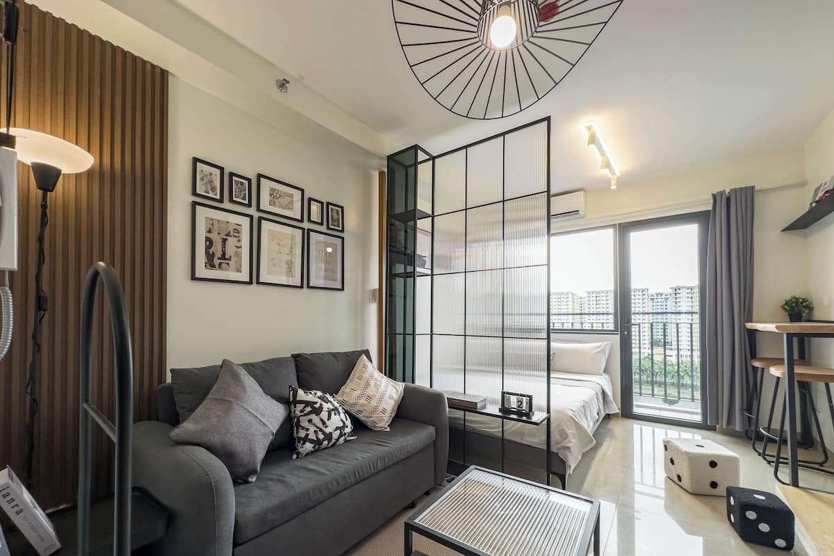 Una sala de estar moderna con un sofá, una mesa de centro y un ventanal con vistas a edificios.