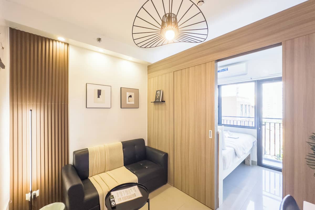 Una sala de estar moderna con un sofá, una mesita y una lámpara de techo.