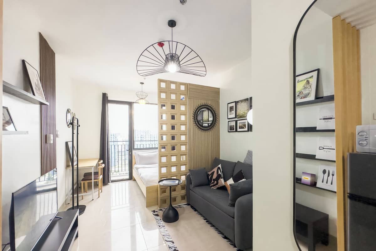 Una sala de estar moderna con un sofá, un televisor, un comedor y una vista a través de la puerta.