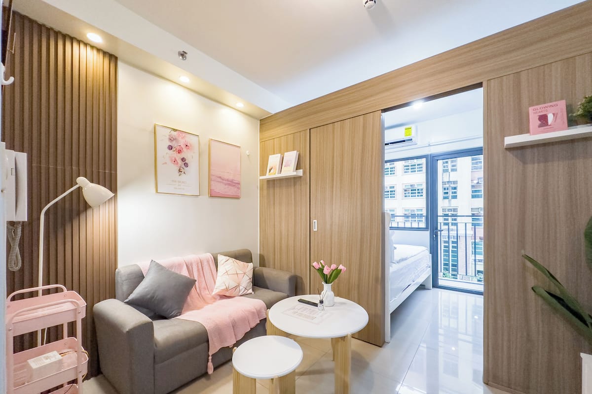 Una sala de estar moderna con un sofá gris, una mesita redonda y una estantería.