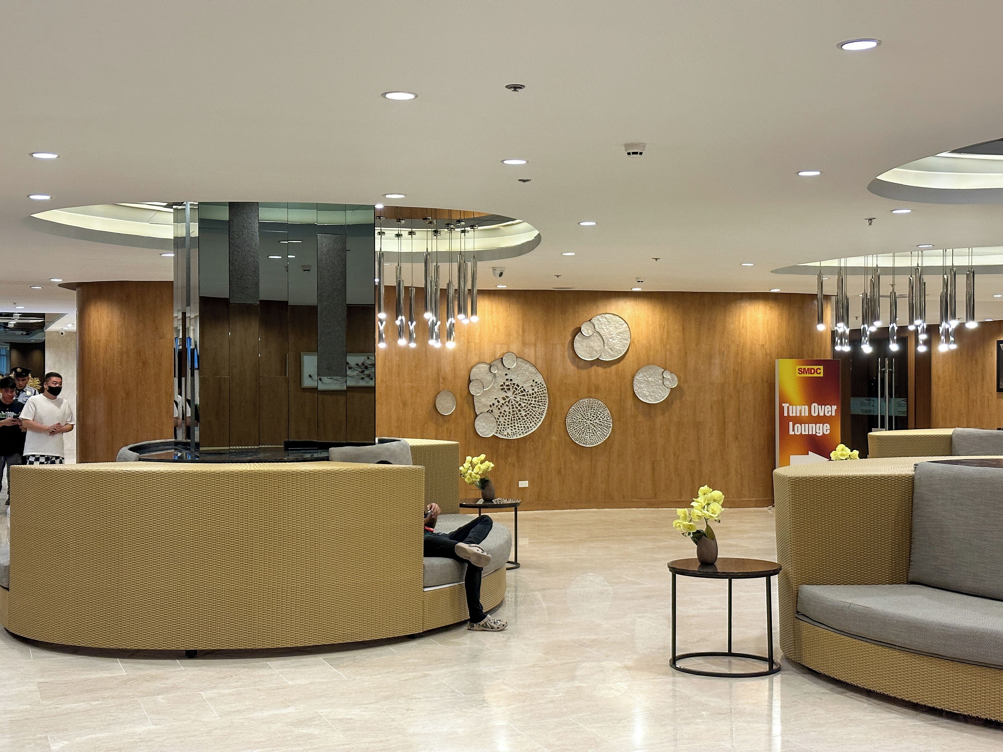 A modern reception area with a curved reception desk, seating arrangements, and decorative wall art.