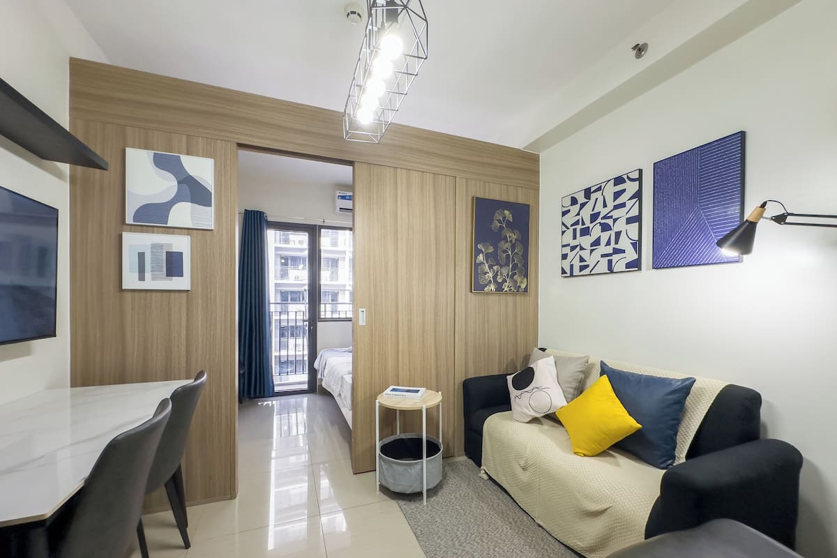 Una sala de estar moderna con un sofá, una mesa de comedor con sillas y una pequeña mesita auxiliar.