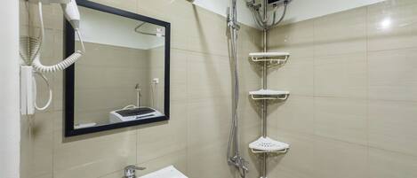 Une salle de bain avec un lavabo, un miroir et une douche.