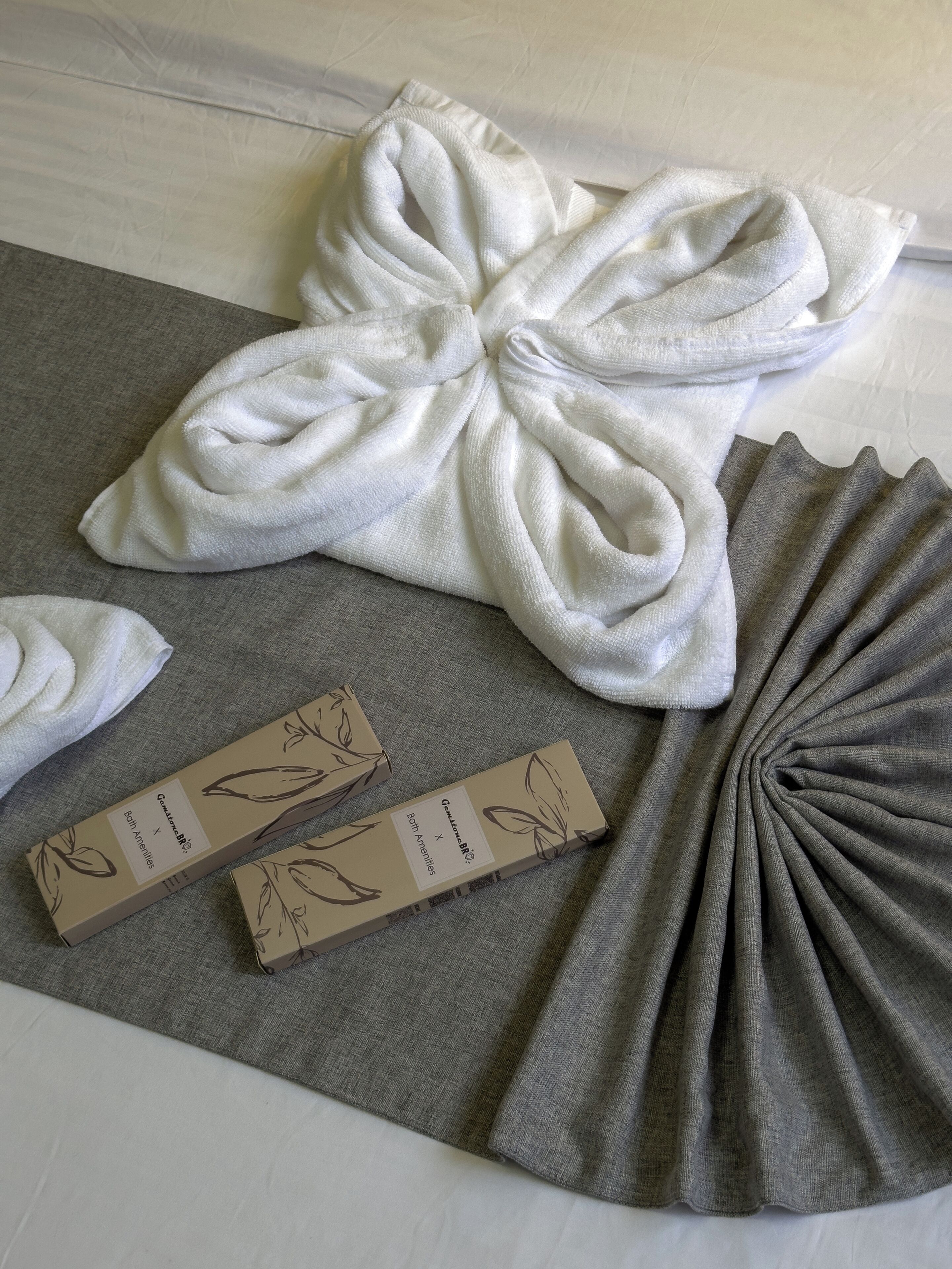 A neatly arranged set of towels and a box on a textured surface.