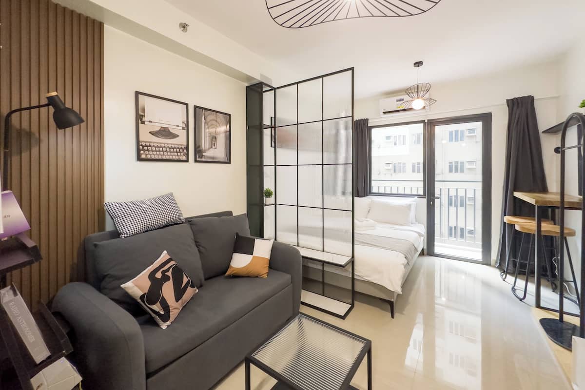 Una sala moderna con un sofá, una mesita de centro y una cama con vistas a la ciudad.