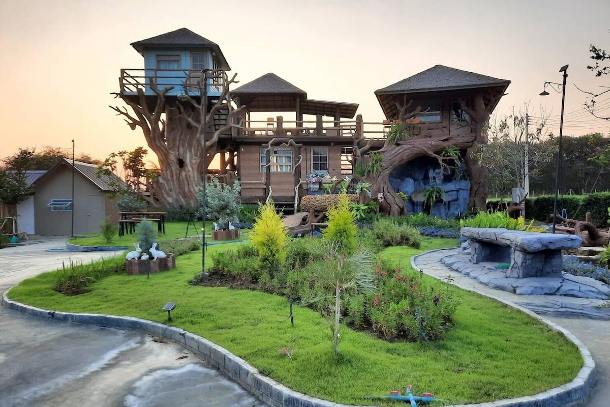 A treehouse-style building with multiple levels and a naturalistic garden.