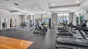 Un gimnasio con cintas de correr, elípticas y pesas libres.