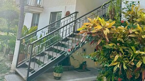 A multi-story building with a balcony, a staircase, and a sign indicating the building number B1. - Cozy Apartment Near the Beach (Mazatlán)