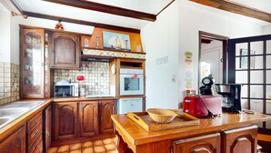 A kitchen with wooden cabinets, a tiled backsplash, a microwave, a toaster, and a coffee maker.