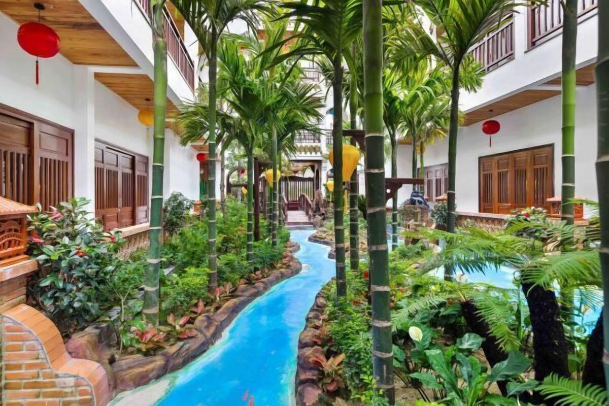 A courtyard with a water feature, bamboo plants, and traditional wooden doors.