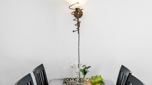 Et spisebord med to stole, en gulvlampe og en vase med blomster.