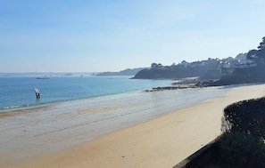 A beach with a sandy shore, calm water, and buildings in the background. - Pet friendly home in Locquénolé with WiFi (Locquénolé)
