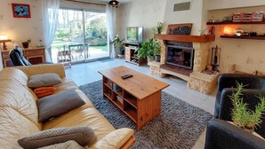 Una sala de estar con un sofá, una mesa de centro, una chimenea y un televisor.