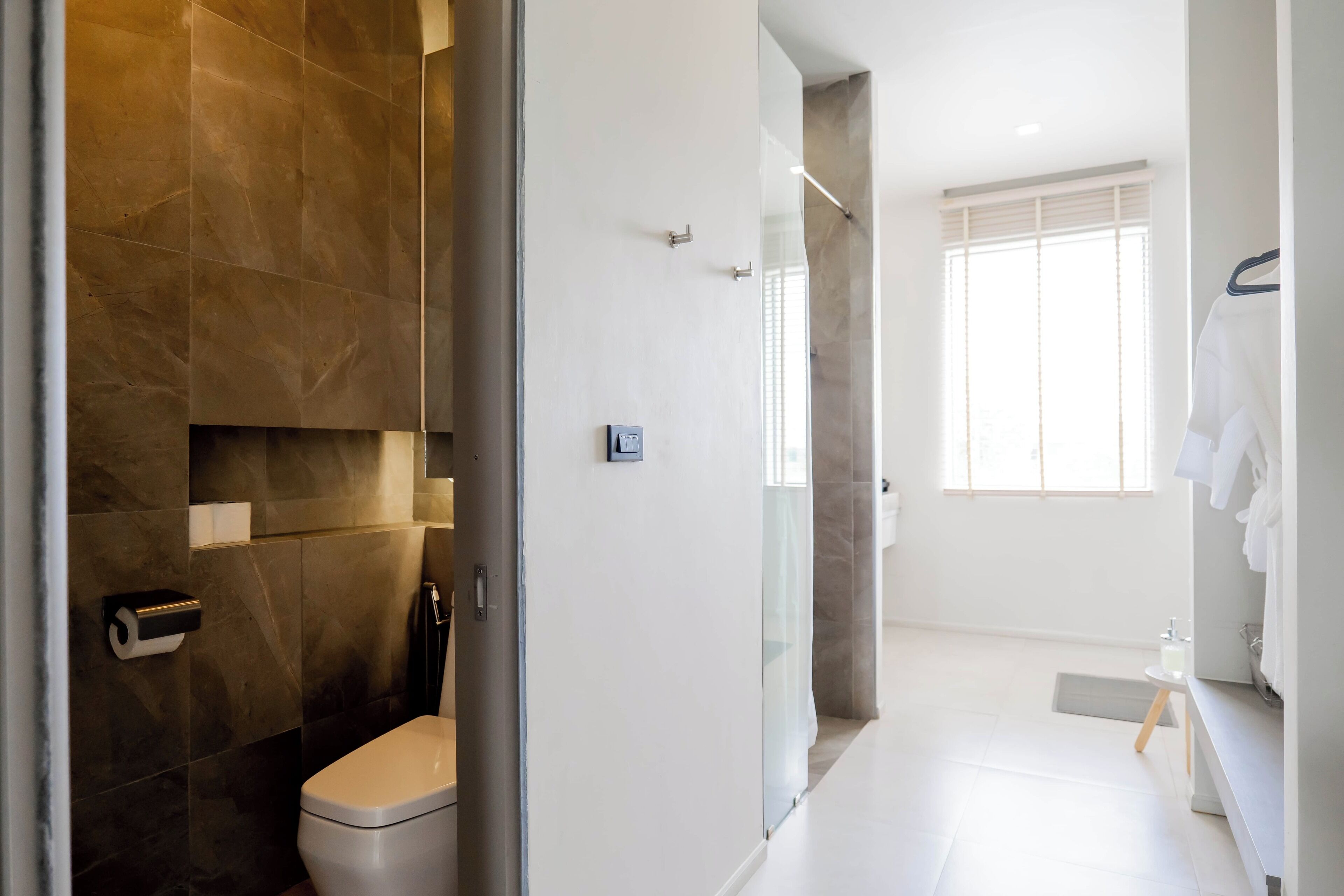 A modern bathroom with a toilet, shower, and sink.