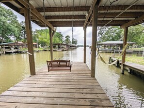 A wooden dock with a bench, wooden pillars, and a metal roof. - Boathouse, 2 King Beds, Firepit, Huge Yard + Pet-Friendly! Peaceful & Luxurious (Livingston)