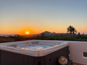 A hot tub on a balcony with a sunset view. - Villa Vaya – Private 180 m² Residence with Jacuzzi and Garden near Agia Anna Beach (Naxos)