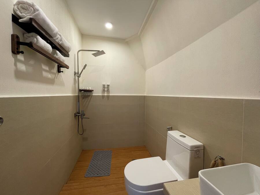 Een kleine, moderne badkamer met douche, toilet en wastafel.