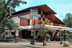 Un edificio moderno con un balcón de madera, un letrero que dice 'WELCOME TO DIWATA' y un cartel de 'NO ENTRY'.