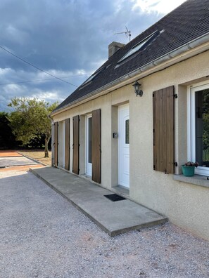 Simple, single-story building with a flat roof and windows with shutters.