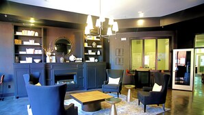 A modern living room with a fireplace, dark furniture, and a bookshelf.