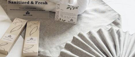 A towel, a box labeled 'Sanitized & Fresh', and two smaller boxes with 'GEMSTONEBR Bath Amenities'.