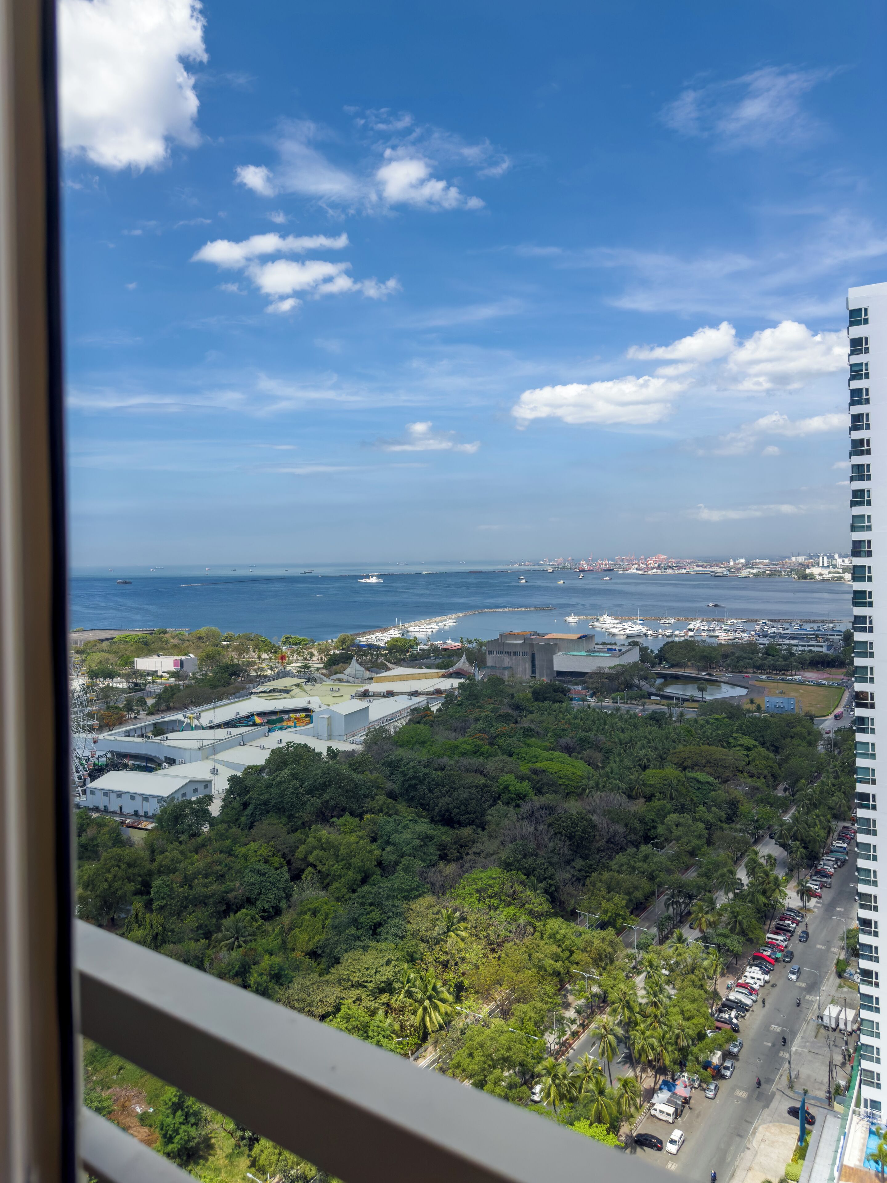 A high-rise hotel with a view of a marina and cityscape.