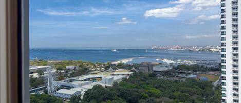 Un paisaje urbano costero con vista al mar, edificios y un parque.