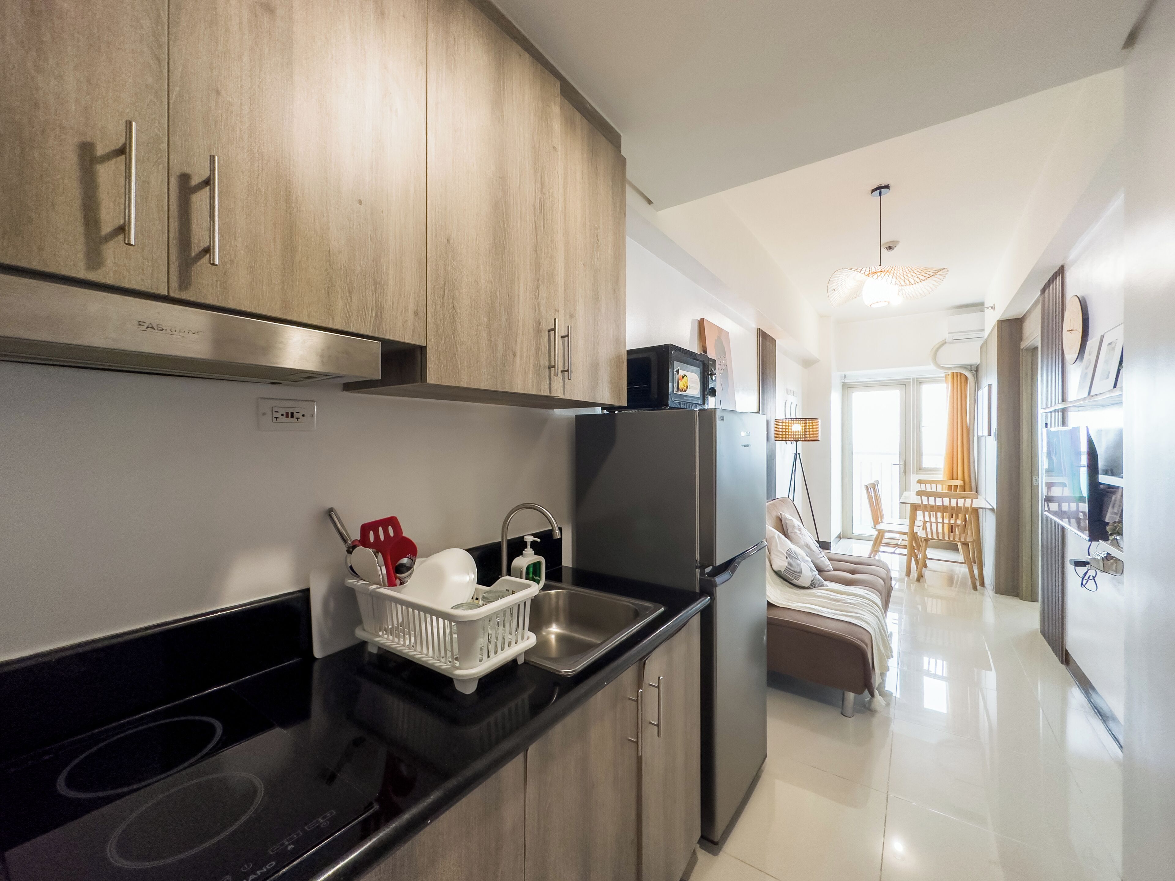 A modern kitchen with stainless steel appliances, wooden cabinets, and a black countertop.