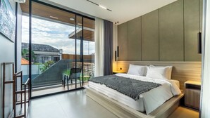 Une chambre moderne avec un grand lit, un balcon offrant une belle vue et une porte-fenêtre coulissante.
