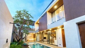 Une maison moderne dotée d’une piscine, d’un balcon et d’un intérieur bien éclairé.