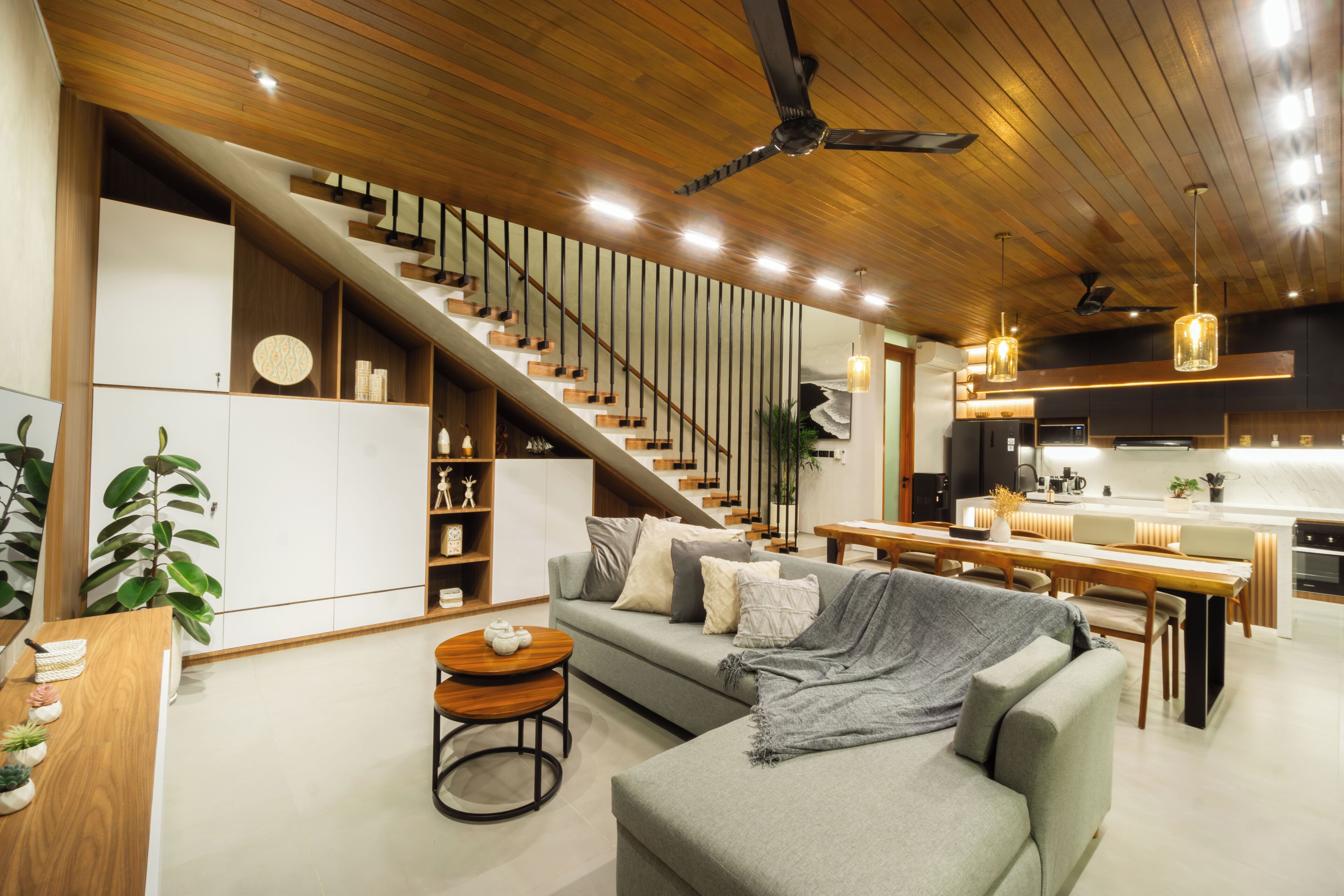 Una cocina moderna con una isla central, electrodomésticos integrados e iluminación colgante.