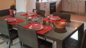 Een moderne keuken met witte kasten, een inbouwoven en een raam boven de gootsteen.