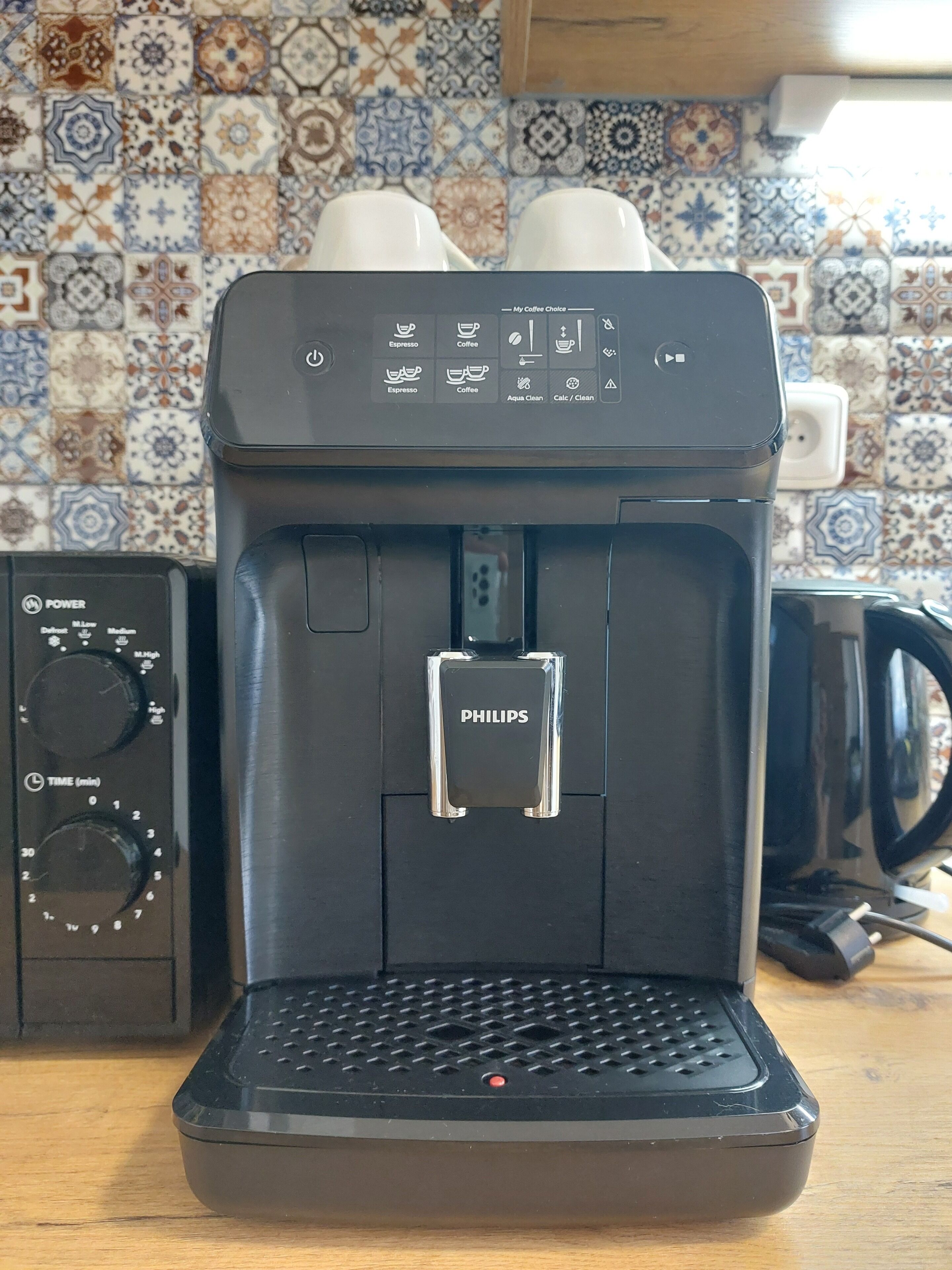 Una cafetera con pantalla digital y depósito de agua.