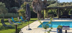 A swimming pool with lounge chairs, a pergola, and a sign indicating the pool is not supervised. - Charming house classified 3 stars/3 ears "Gîtes de France" surrounded by nature
 (Istres)