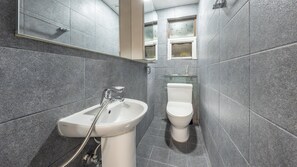 Un baño moderno con lavamanos, inodoro y cabina de ducha de vidrio.