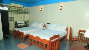 Una habitación con dos camas de madera, una mesa de madera y una silla.