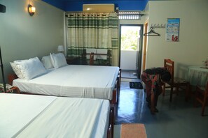 A hotel room with two beds, a table with a tablecloth, a chair, a hanging coat rack, and a calendar on the wall. - AKR hotel (Kilinochchi)