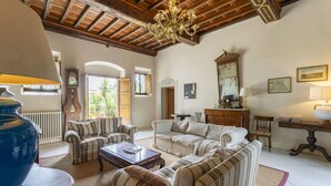 A spacious living room with a high ceiling, a chandelier, and a large window. - Wonderful  villa with private pool, WIFI, A/C, TV, terrace, pets allowed and panoramic view (Pistoia)