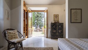A room with a bed, a chair, a cabinet, and a door leading to an outdoor area. - Wonderful  villa with private pool, WIFI, A/C, TV, terrace, pets allowed and panoramic view (Pistoia)