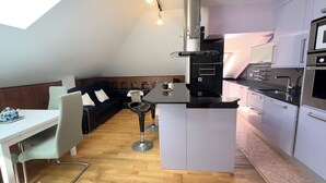 A compact kitchen with a dining area, a built-in stove, and a small island.