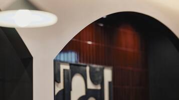 An interior view of a modern building with a geometric wall design and a wooden panel backdrop.