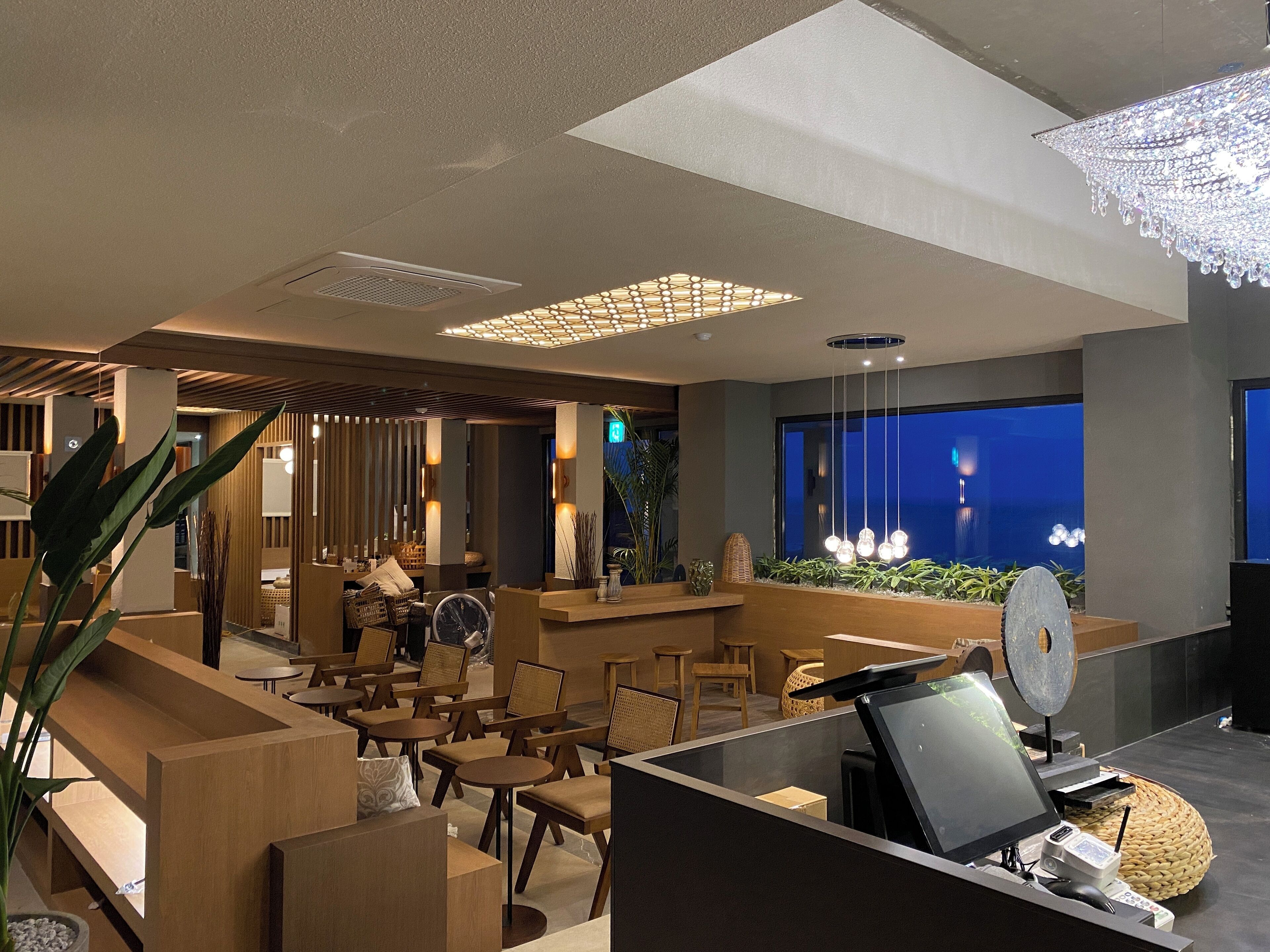 A modern hotel lobby with a reception desk, seating area, and a large aquarium.