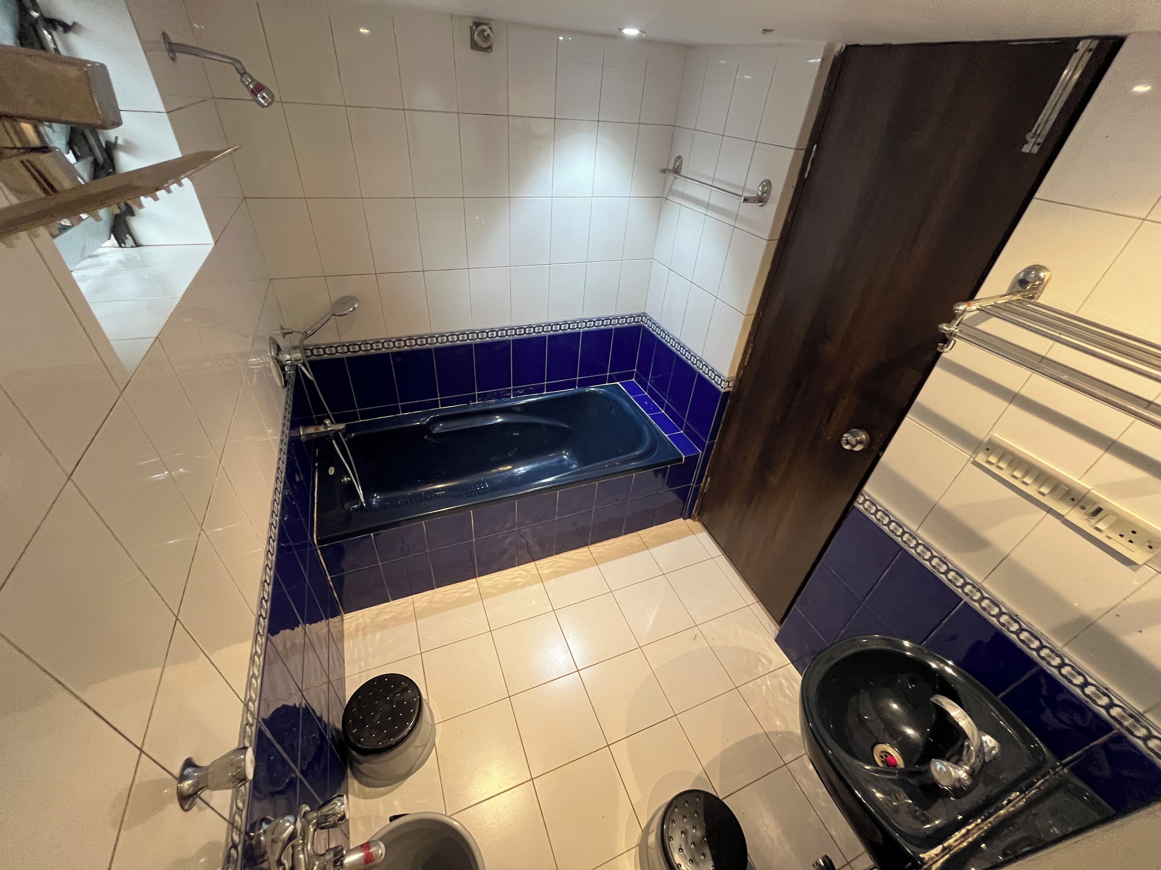 A bathroom with a bathtub, a toilet, and a shower area.