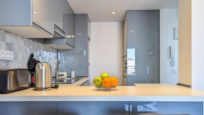 A modern kitchen with a countertop, a fruit bowl, and a toaster. - TROPIC MAR sweet apartment (Benidorm)