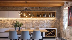 A modern kitchen with a stone wall, wooden ceiling beams, and a wine rack. - Villa Mar is a place of pure serenity and relaxation with its beautiful views (Orašac)