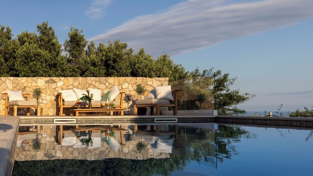 A pool area with stone walls, lounge chairs, and a view of trees. - Villa Mar is a place of pure serenity and relaxation with its beautiful views (Orašac)