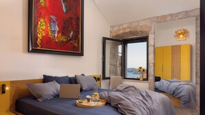 A modern bedroom with a large bed, a laptop, a tray with a drink and a glass, and a large abstract painting. - Villa Mar is a place of pure serenity and relaxation with its beautiful views (Orašac)