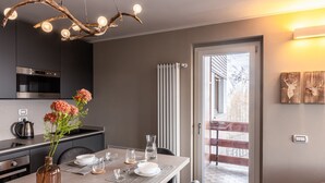 A modern kitchen with a dining area, a large window, and a view of the outdoors.