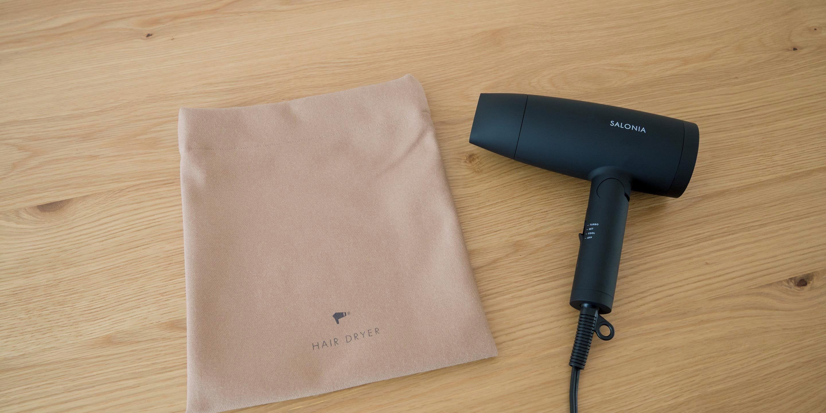Un sèche-cheveux et un paquet beige sur une surface en bois.